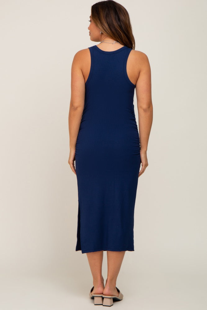 woman wearing a navy blue sleeveless maternity dress with side slits, showing her baby bump from the back