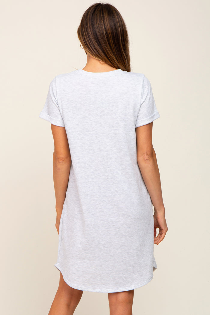woman wearing a light gray short sleeve t-shirt dress with a curved hem and relaxed fit, shown from the back