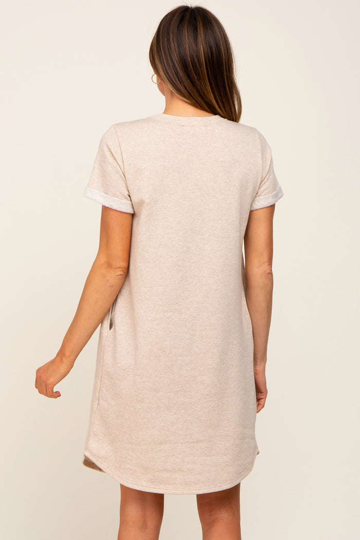 woman wearing a light beige short sleeve casual dress with rolled cuffs and a relaxed fit, viewed from the back