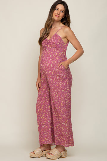 pregnant woman wearing a pink floral maternity jumpsuit and woven platform sandals
