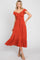 woman wearing a rust red off-the-shoulder midi dress with ruched bodice and ruffled hem