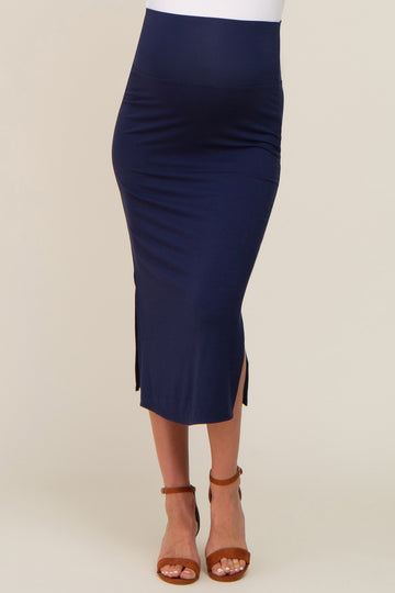 woman wearing a navy blue maternity midi skirt with side slits and brown ankle strap sandals