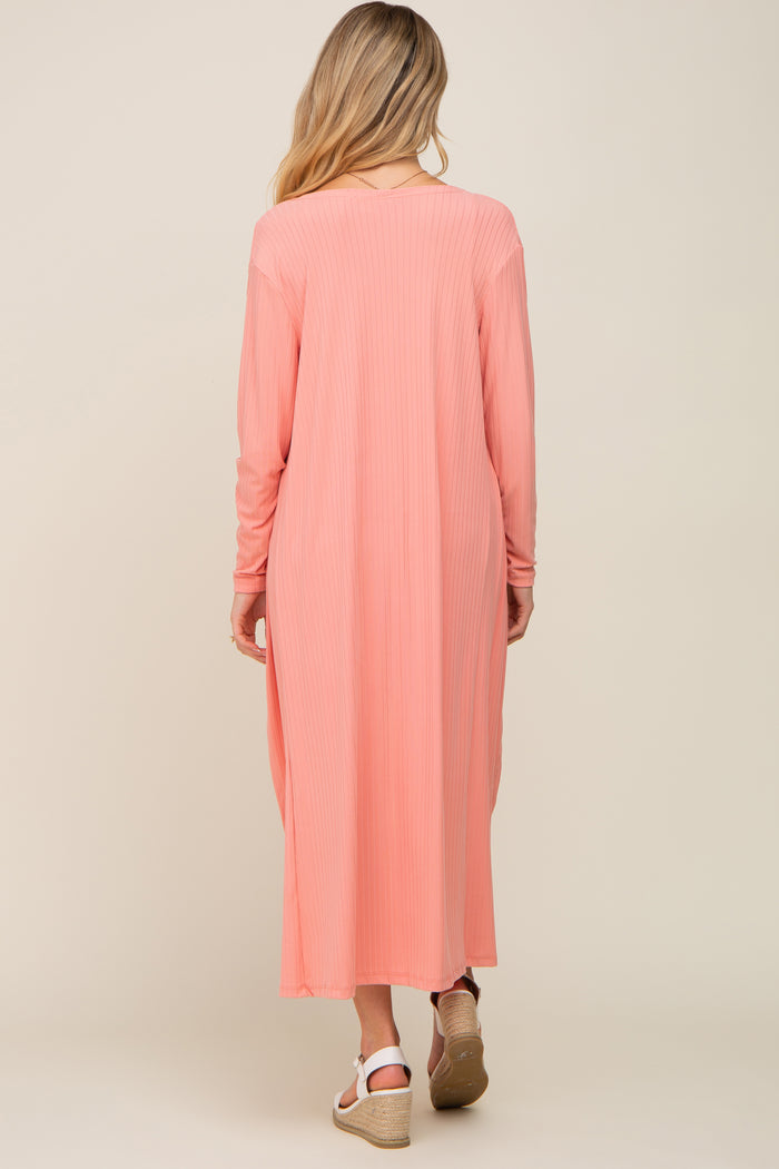 woman wearing a light pink long sleeve maternity dress with a ribbed texture, seen from the back