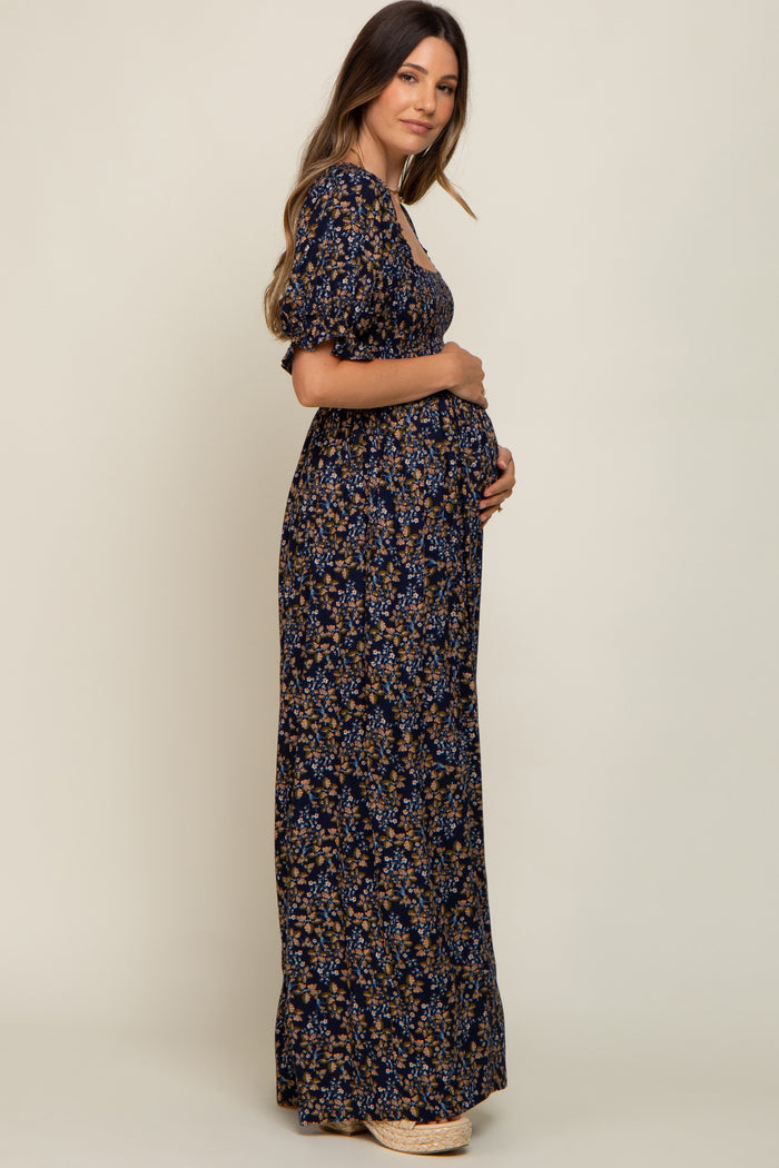woman wearing a navy floral maternity maxi dress and holding her baby bump