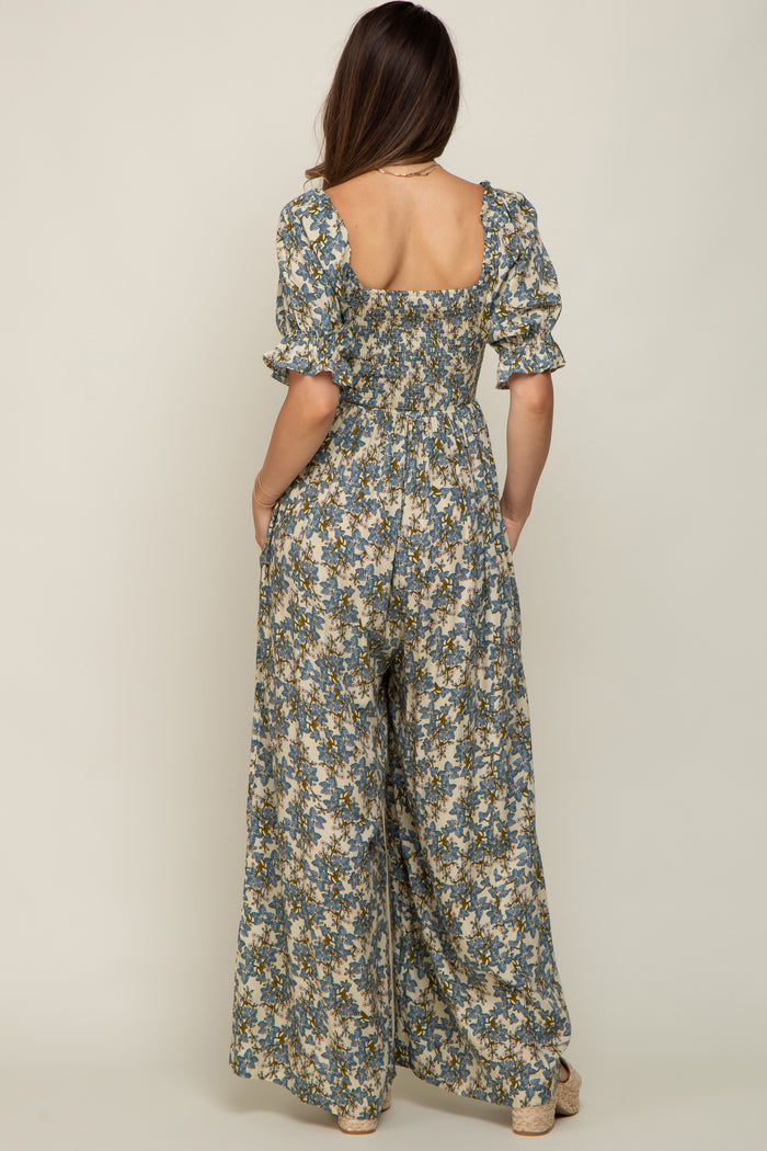 woman wearing a floral maternity jumpsuit with puffed sleeves and a loose fit, showcasing a pregnant belly from the back