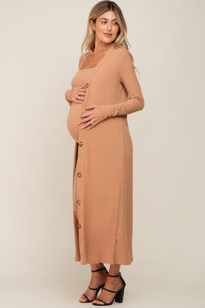 woman wearing a tan ribbed maternity dress with buttons and holding her baby bump