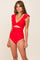 woman wearing a red ruffled one-piece swimsuit with a twist front design