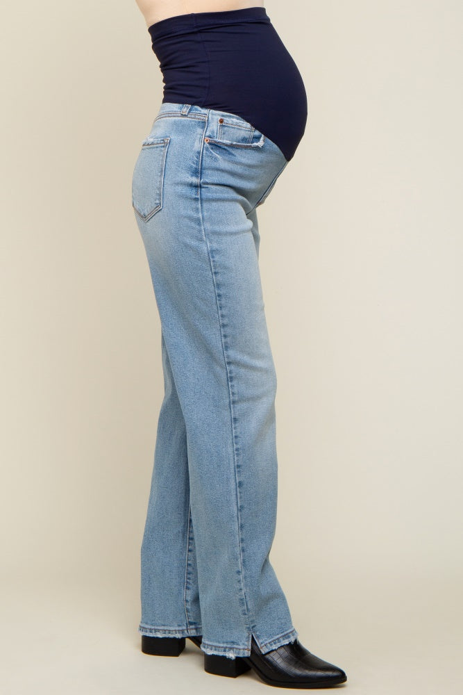 woman wearing light blue maternity jeans with a navy blue belly panel and a visible baby bump
