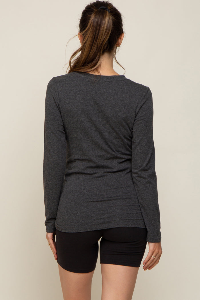 woman wearing a dark gray long sleeve maternity top viewed from the back with black shorts