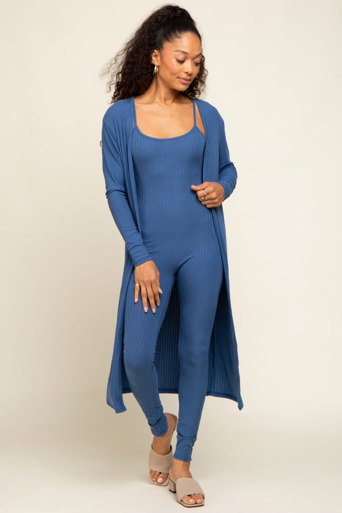 woman wearing a blue ribbed jumpsuit with an open front cardigan and heeled sandals