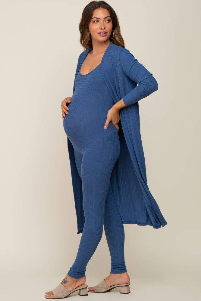 woman wearing a blue maternity jumpsuit with a matching open cardigan and showing her baby bump
