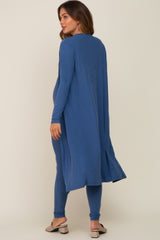 woman wearing a dark blue maternity cover-up with long sleeves and side slits, paired with matching leggings