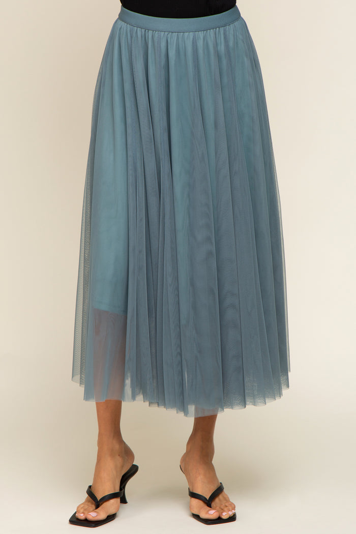 woman wearing a sheer teal tulle midi skirt with an elastic waistband and flowy layered design