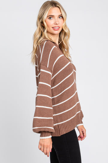 woman wearing a brown and white striped oversized knit sweater with balloon sleeves