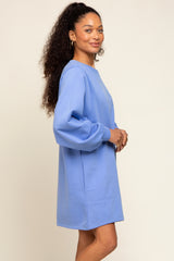 woman wearing a light blue oversized sweatshirt dress with puff sleeves and a crew neck