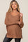 woman wearing a mauve v-neck maternity sweater with relaxed fit and long sleeves, highlighting her baby bump