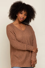 woman wearing a brown oversized knit sweater with a v-neckline and long sleeves
