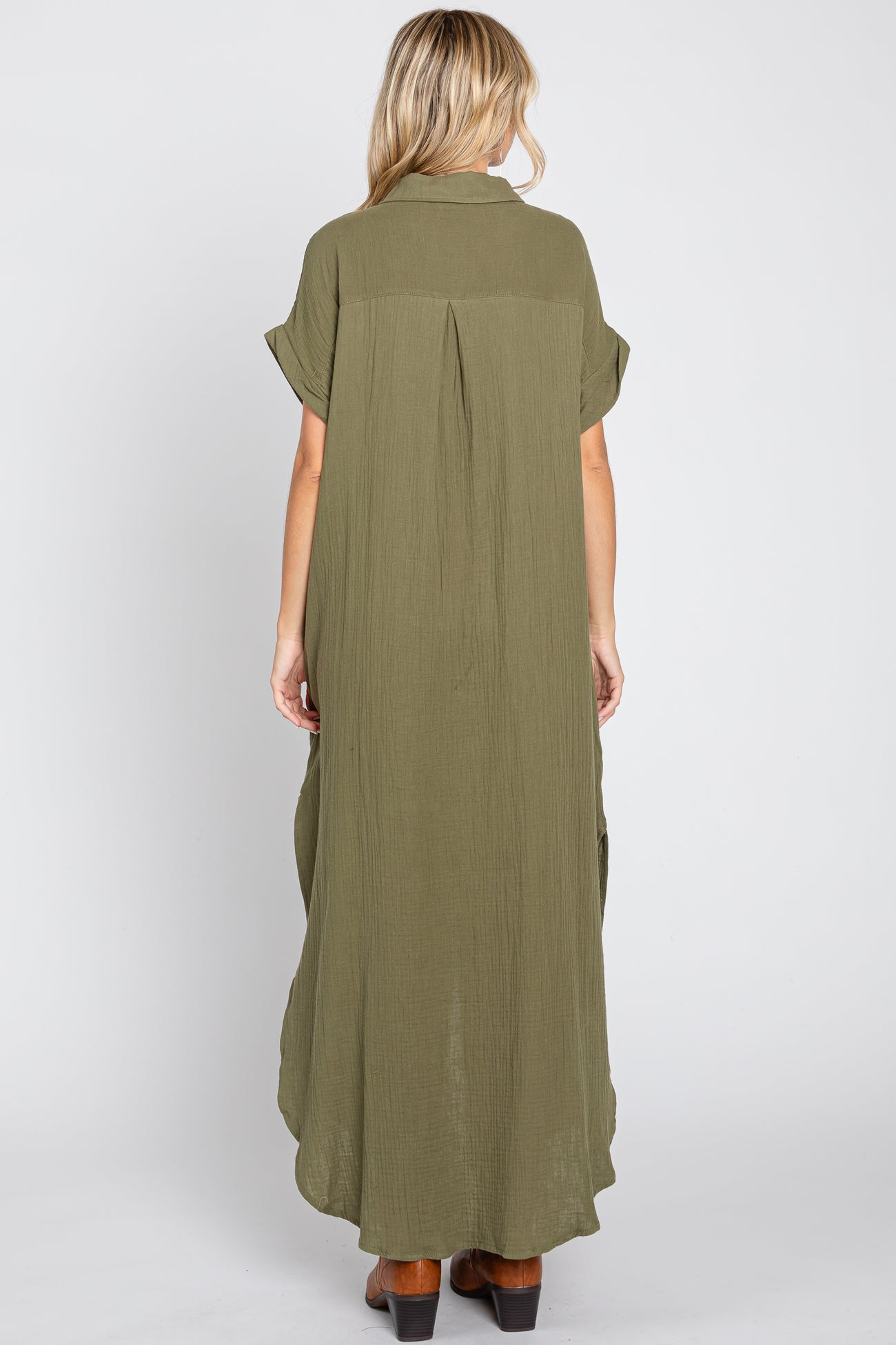 woman wearing an olive green maxi dress with short sleeves and a flowy back design