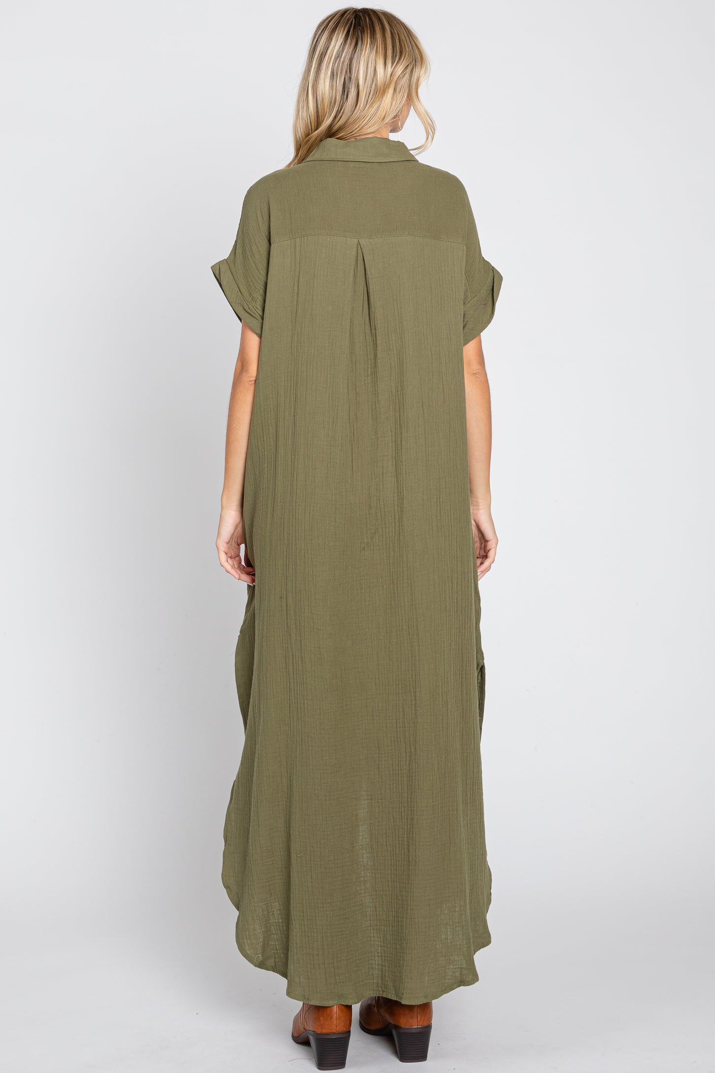 woman wearing an olive green maxi dress with short sleeves and a flowy back design