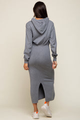 woman wearing a gray hoodie dress with a fitted silhouette and back slit, standing with her back to the camera