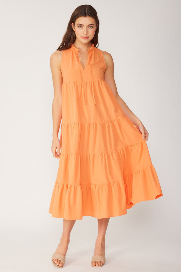 woman wearing an orange tiered midi dress with a v-neck and ruffled hem