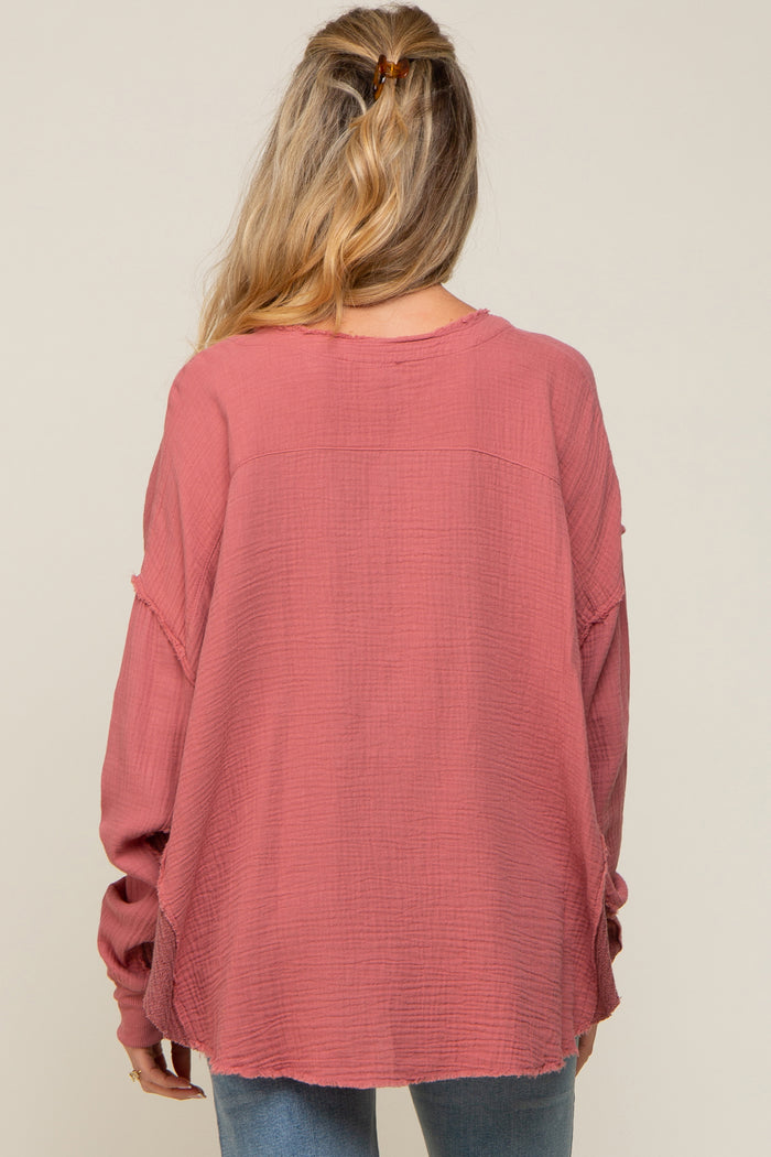 woman wearing a long sleeve dusty rose maternity top with a relaxed fit and frayed hem