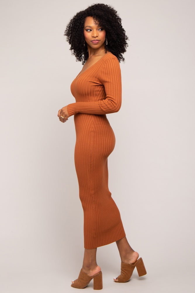 woman wearing a rust-colored ribbed knit midi dress with long sleeves and side slit, styled with nude block heel sandals