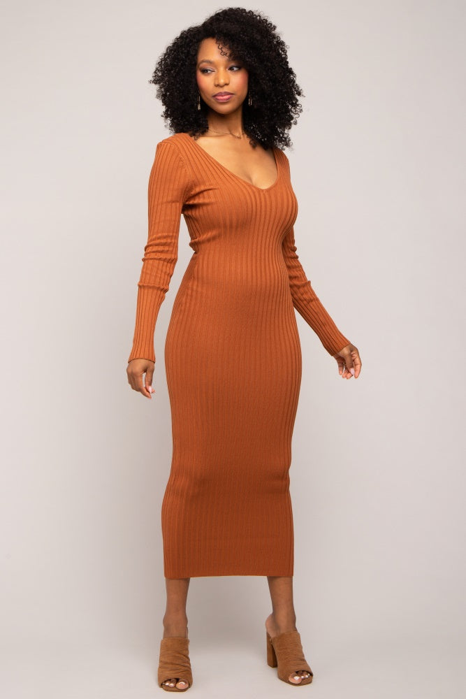 woman wearing a rust-colored ribbed long sleeve midi dress with a deep v-neck and fitted silhouette