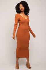 woman wearing a rust-colored ribbed long sleeve midi dress with a deep v-neck and fitted silhouette