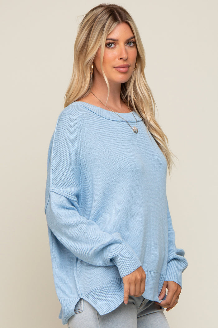 woman wearing a light blue oversized knit sweater with dropped shoulders and long sleeves