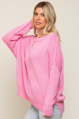 woman wearing an oversized light pink sweater with dropped shoulders and a relaxed fit