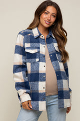 woman wearing a navy and white plaid maternity shirt jacket with a visible baby bump and light blue jeans