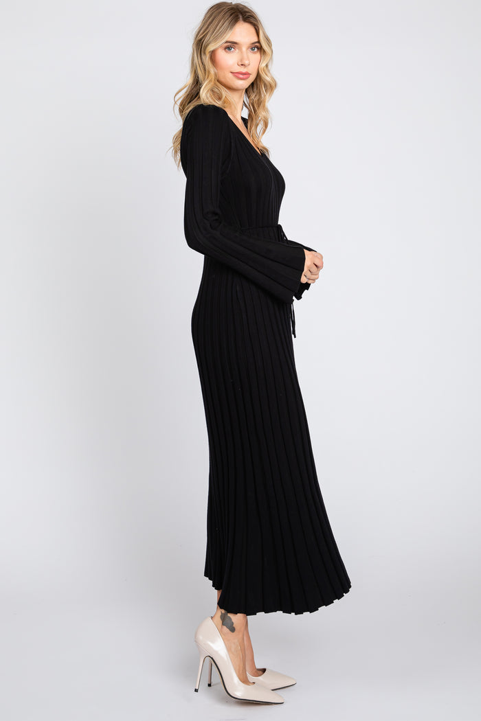 woman wearing a black ribbed knit maxi dress with long sleeves and a tie waist detail