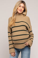 woman wearing a tan striped maternity sweater with a relaxed fit and slightly oversized sleeves, showing her baby bump