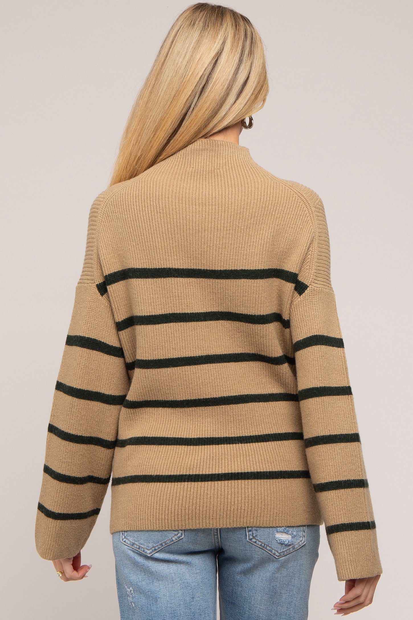 woman wearing a tan and green striped maternity sweater with a relaxed fit and wide sleeves, viewed from the back