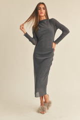 woman wearing a fitted gray long sleeve midi dress with a slight sheen and posing with her hair down
