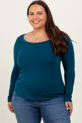 woman wearing a teal long sleeve top with a scoop neckline paired with blue jeans
