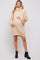 woman wearing a beige oversized turtleneck maternity sweater dress and holding her baby bump