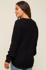 woman wearing a black knitted maternity sweater, shown from the back with long sleeves and a relaxed fit