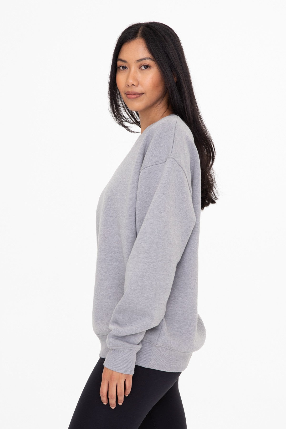 woman wearing a gray oversized sweatshirt with a relaxed fit and long sleeves
