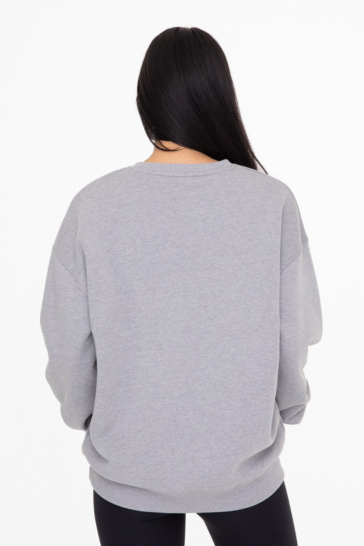 woman wearing a gray oversized sweatshirt from the back with long sleeves and a relaxed fit