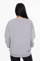woman wearing a gray oversized sweatshirt from the back with long sleeves and a relaxed fit