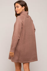 woman wearing a mauve oversized maternity sweater dress with a turtleneck and long sleeves, showcasing a relaxed fit