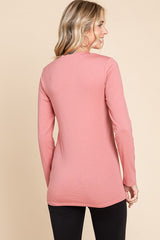 woman wearing a pink long sleeve top with a relaxed fit, shown from the back