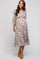 woman wearing a floral patterned maternity dress with long sleeves and a knee-length skirt, showcasing a baby bump