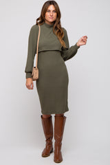 woman wearing a long sleeve olive green ribbed knit dress paired with brown knee-high boots and a small crossbody bag