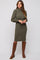 woman wearing an olive green ribbed midi dress with a high neckline and long sleeves, paired with brown knee-high boots