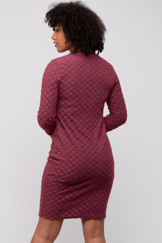 woman wearing a burgundy textured long sleeve dress, showing the back view with a fitted silhouette