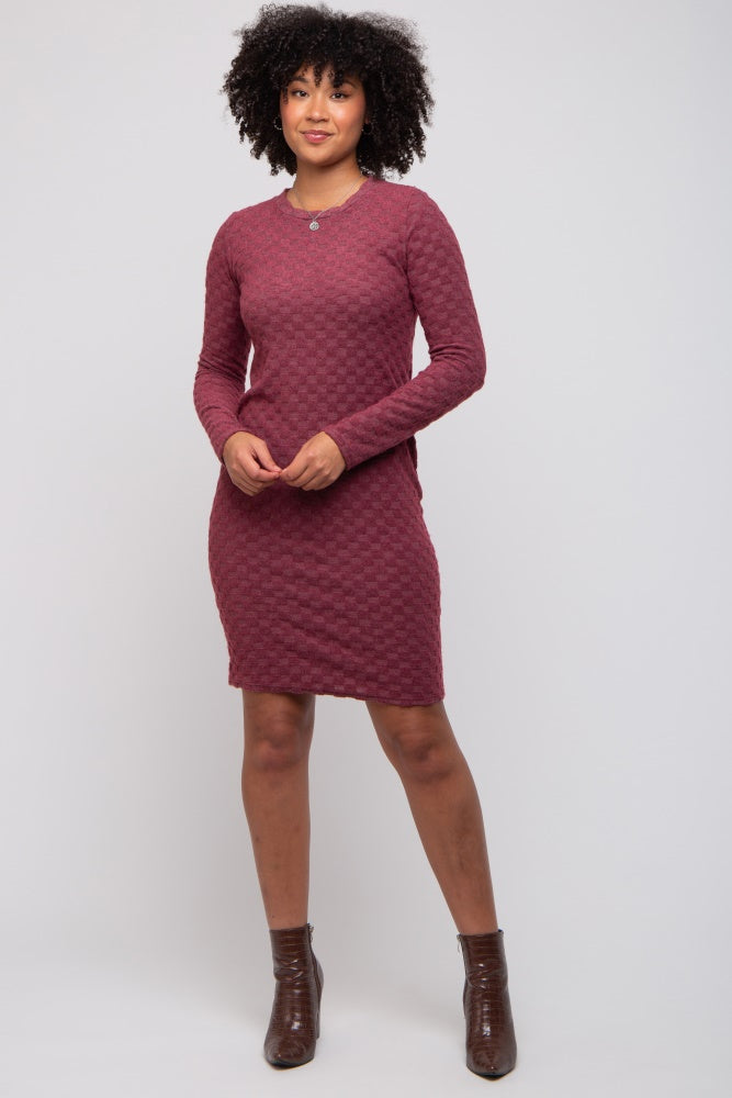 woman wearing a maroon long sleeve textured dress with a round neckline and knee-length hem
