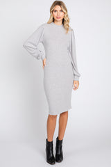 woman wearing a grey ribbed long sleeve midi dress and black ankle boots